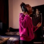 Singer recording vocals in a home vocal booth