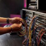 Hands connecting audio cables in mixing studio