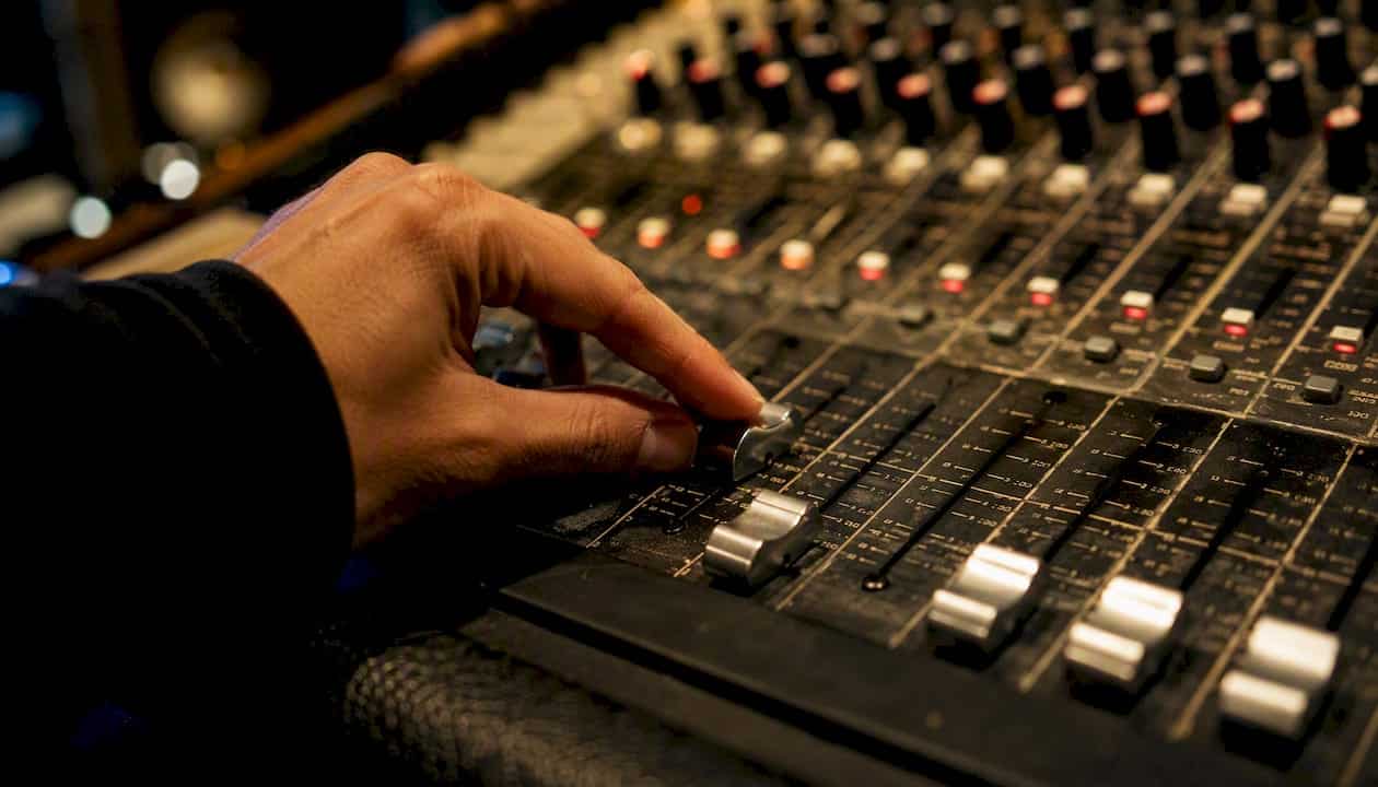 Hand adjusting mixing console fader