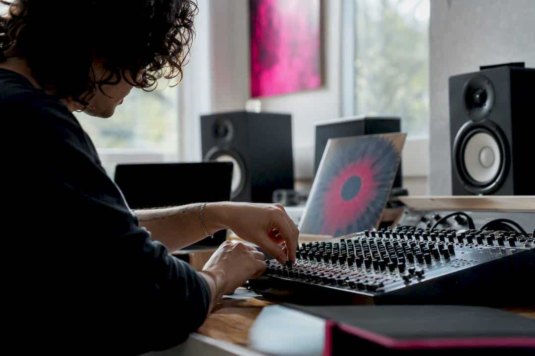 Hands adjusting mixing console dials