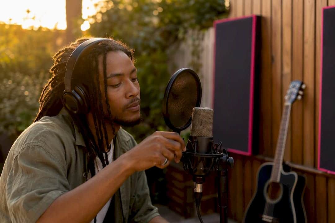 Hand adjusting microphone in bedroom studio