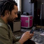 Musician browsing an artist profile on his phone