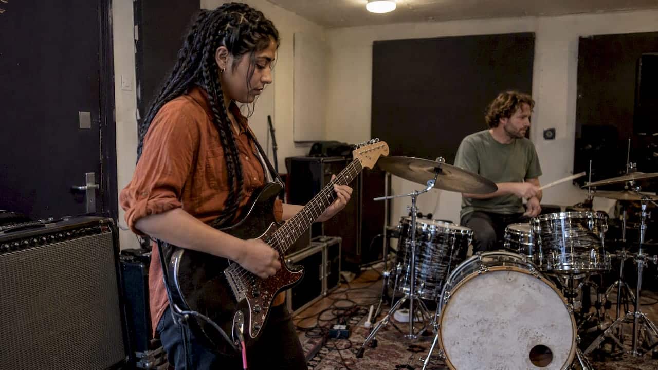Bandmates rehearsing a transition in a practice room