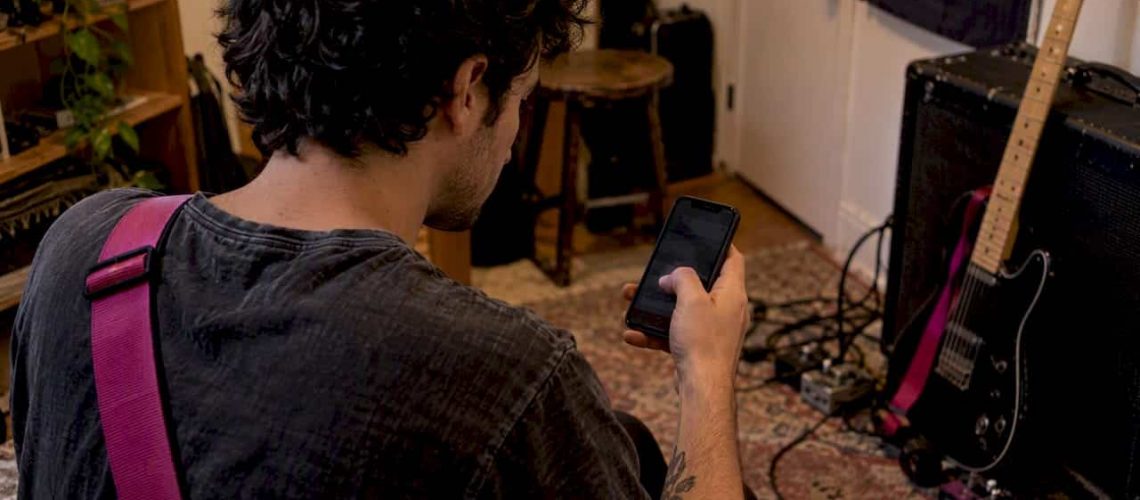 Musician checking Instagram post performance after rehearsal